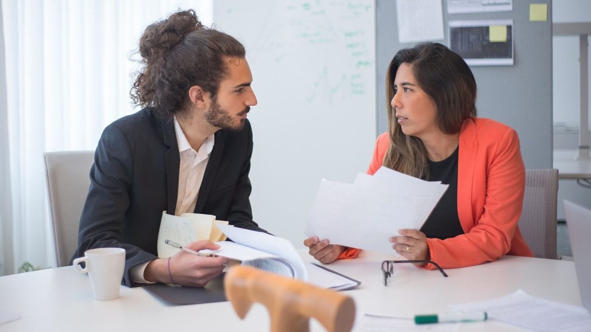 Two colleagues sit across from each other at a table